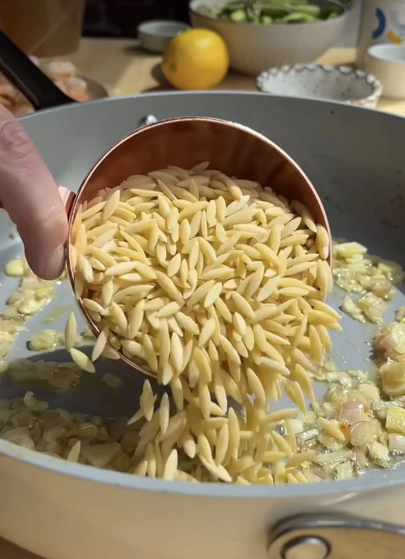 Orzo in die Pfanne geben