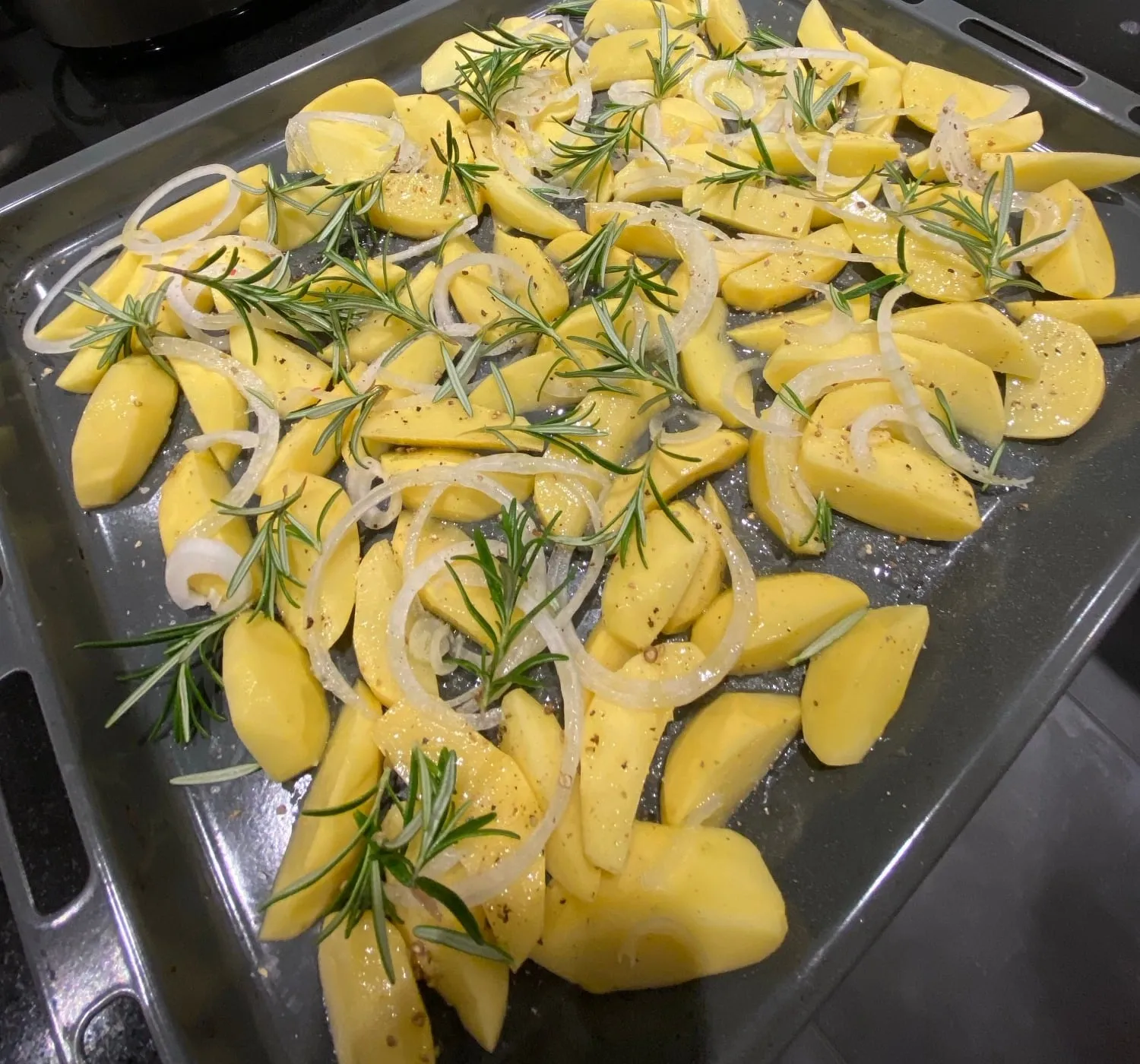 Kartoffeln mit Zwiebeln und Rosmarin vor dem Backen