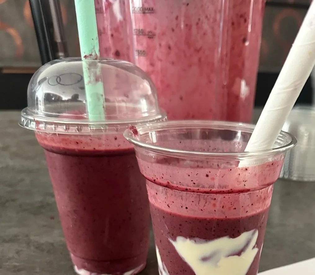 Blaubeer-Maracuja-Smoothie im Glas mit Joghurt-Schlieren