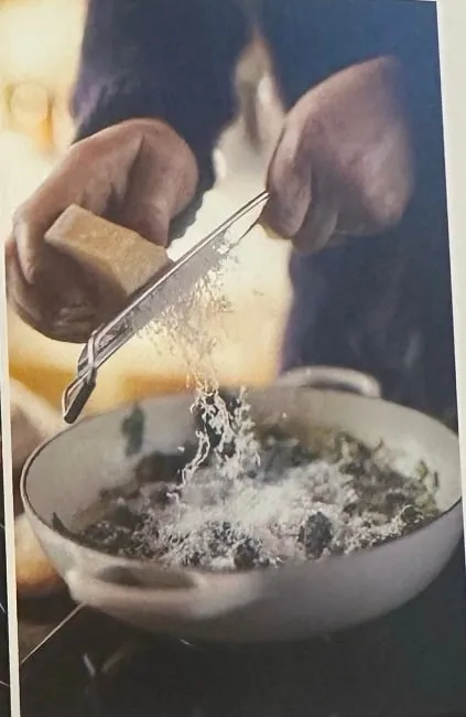 Parmesan über den Spinat reiben